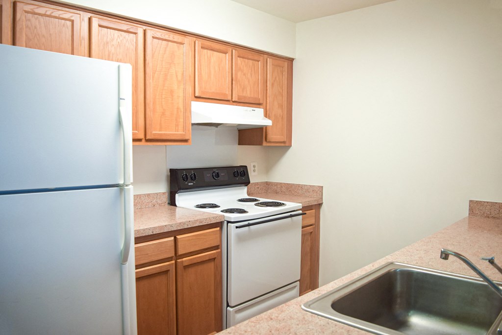 a kitchen with white appliances and wooden cabinets