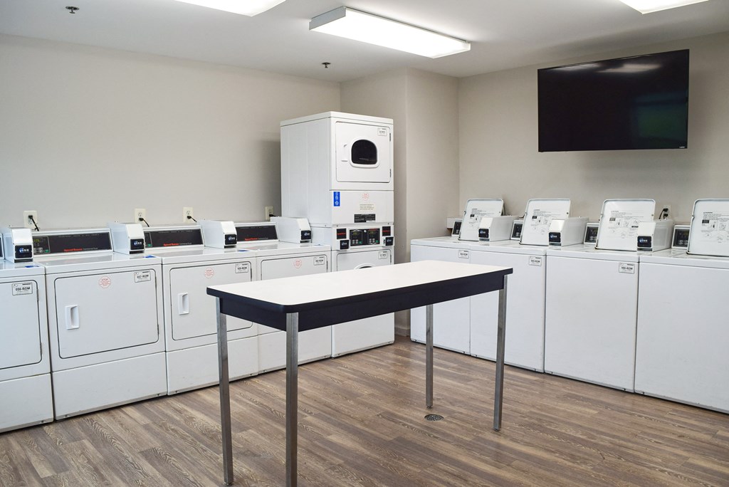a room full of washers and dryers with a table in front of them