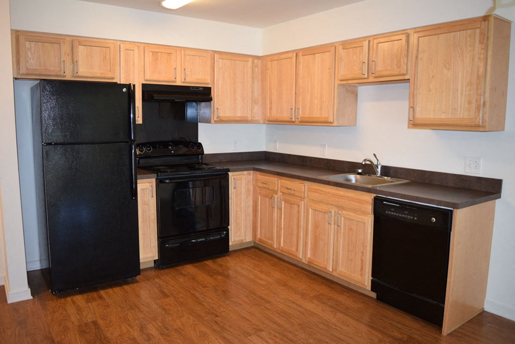 a kitchen with black appliances and wooden cabinets