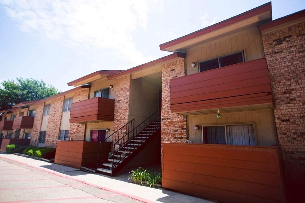 a row of apartments with stairs and a sidewalk