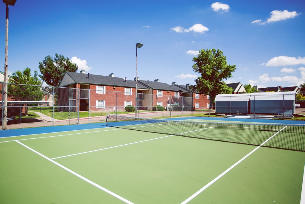 two tennis courts with apartments in the background