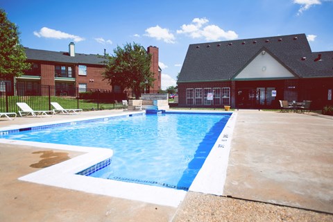 a swimming pool with a house in the background
