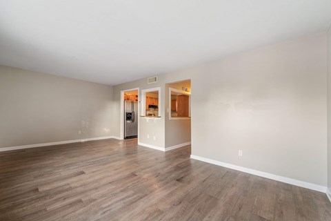 A room with a white wall and a wooden floor.