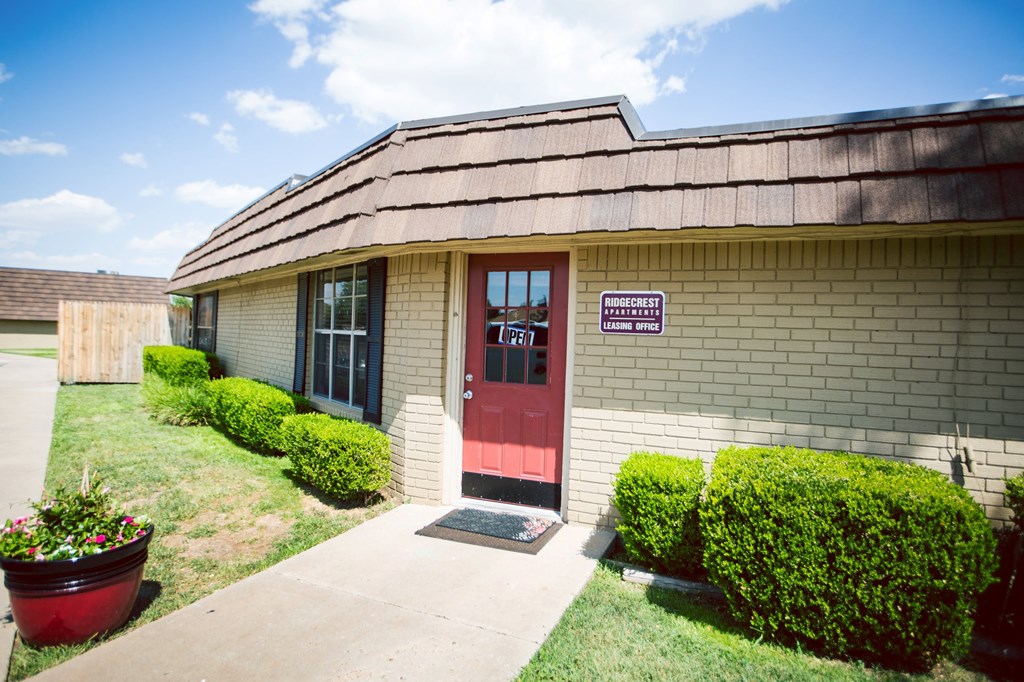 the front of a brick building with a red door