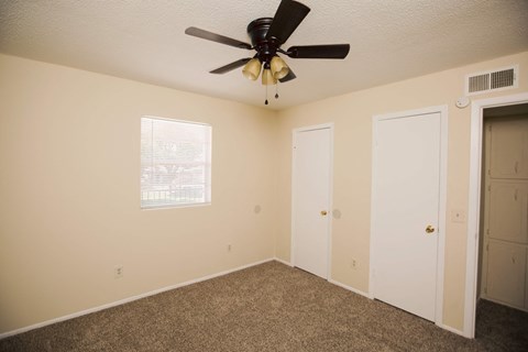 a bedroom with a ceiling fan and a door