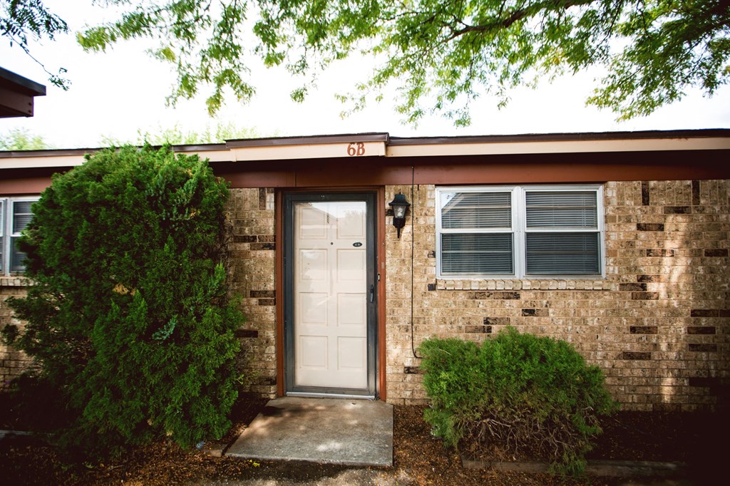 the front of a brick house with a white door