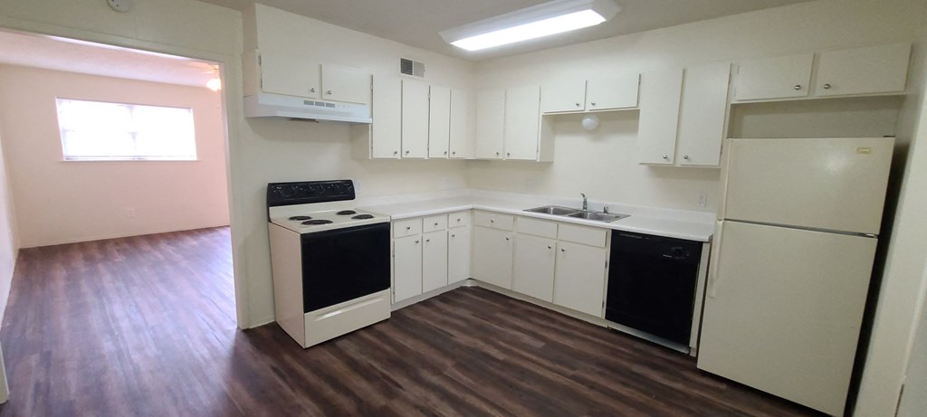 an empty kitchen with white cabinets and black appliances