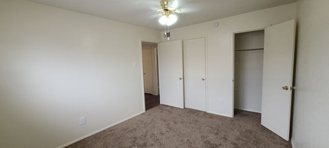 a bedroom with a carpeted floor and a closet