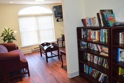 a living room with a bookshelf full of books and a couch and chair