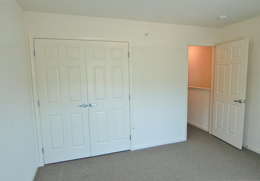 a bedroom with two doors and a closet