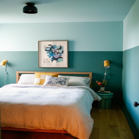 a bedroom with a bed and a painting on the wall