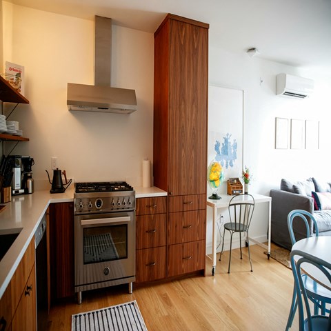 a kitchen with a stove and a table and a living room