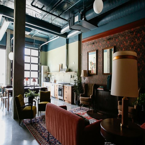 a living room with furniture and a kitchen in the background