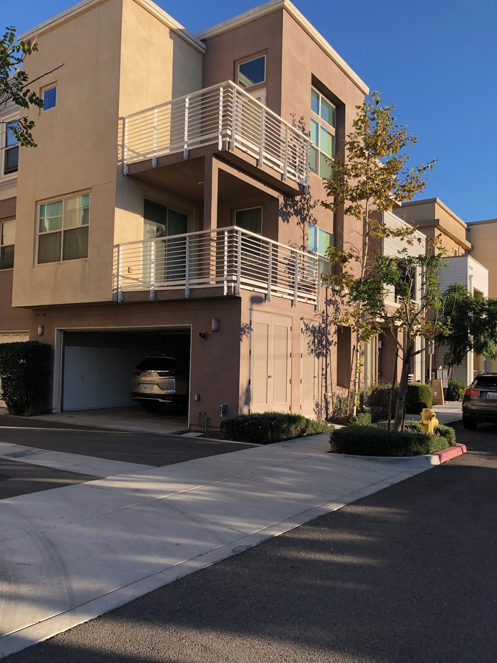 A modern apartment building with a car parked in the driveway.