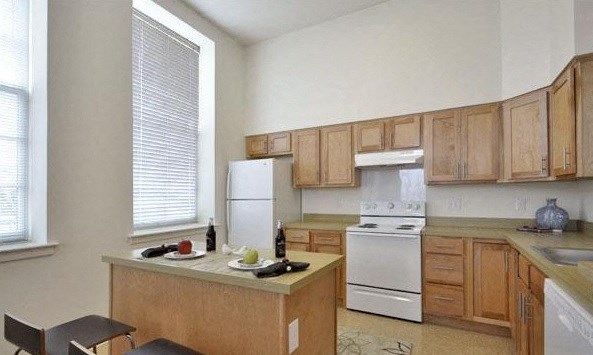 a kitchen with wooden cabinets and white appliances