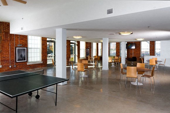a large room with a ping pong table and chairs