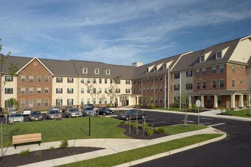 an apartment building with cars parked in a parking lot