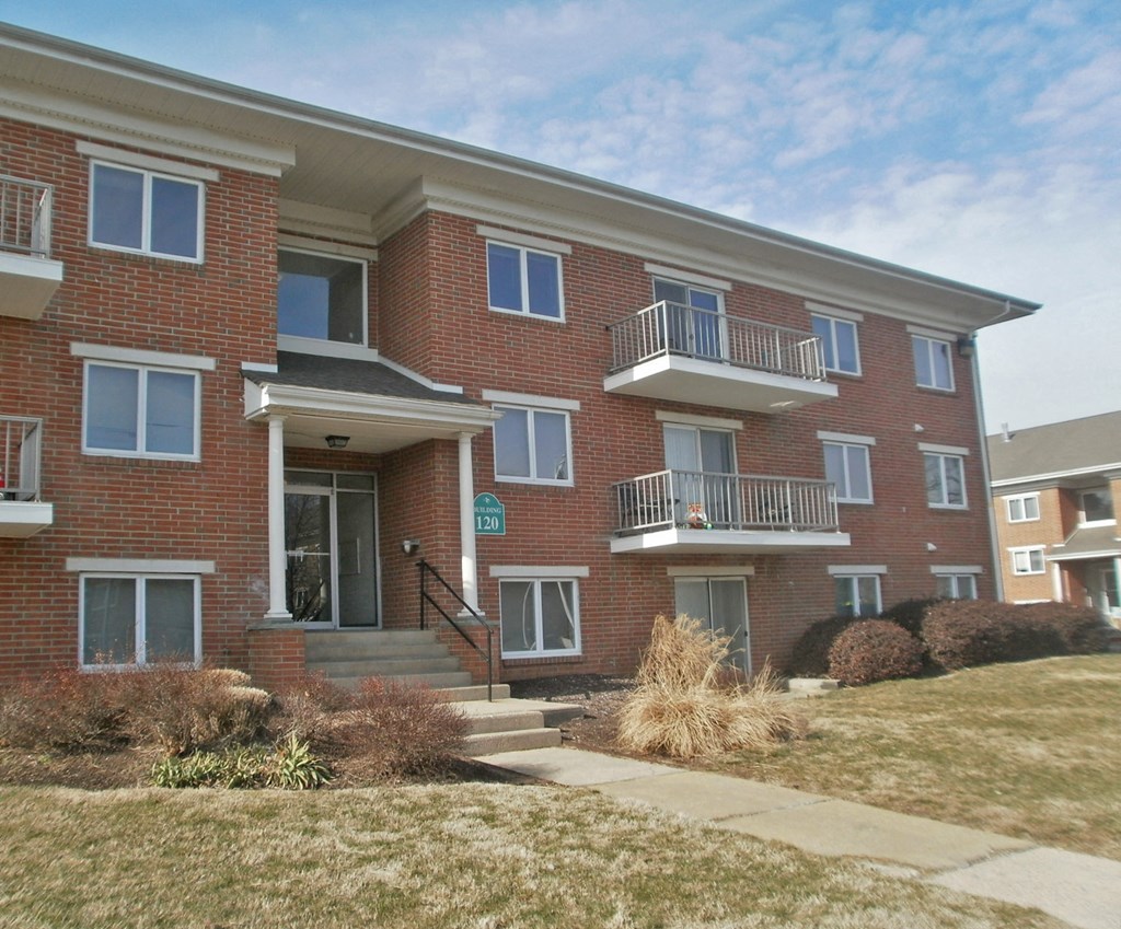 a red brick apartment building with stairs and a sidewalk