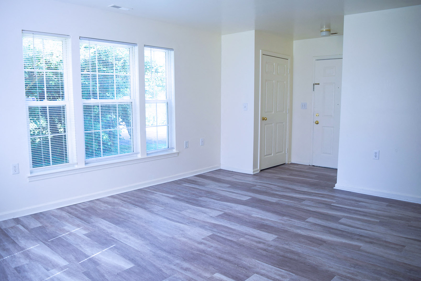 an empty living room with a window and a door