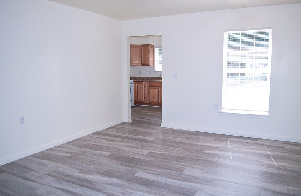 an empty living room with white walls and wood flooring