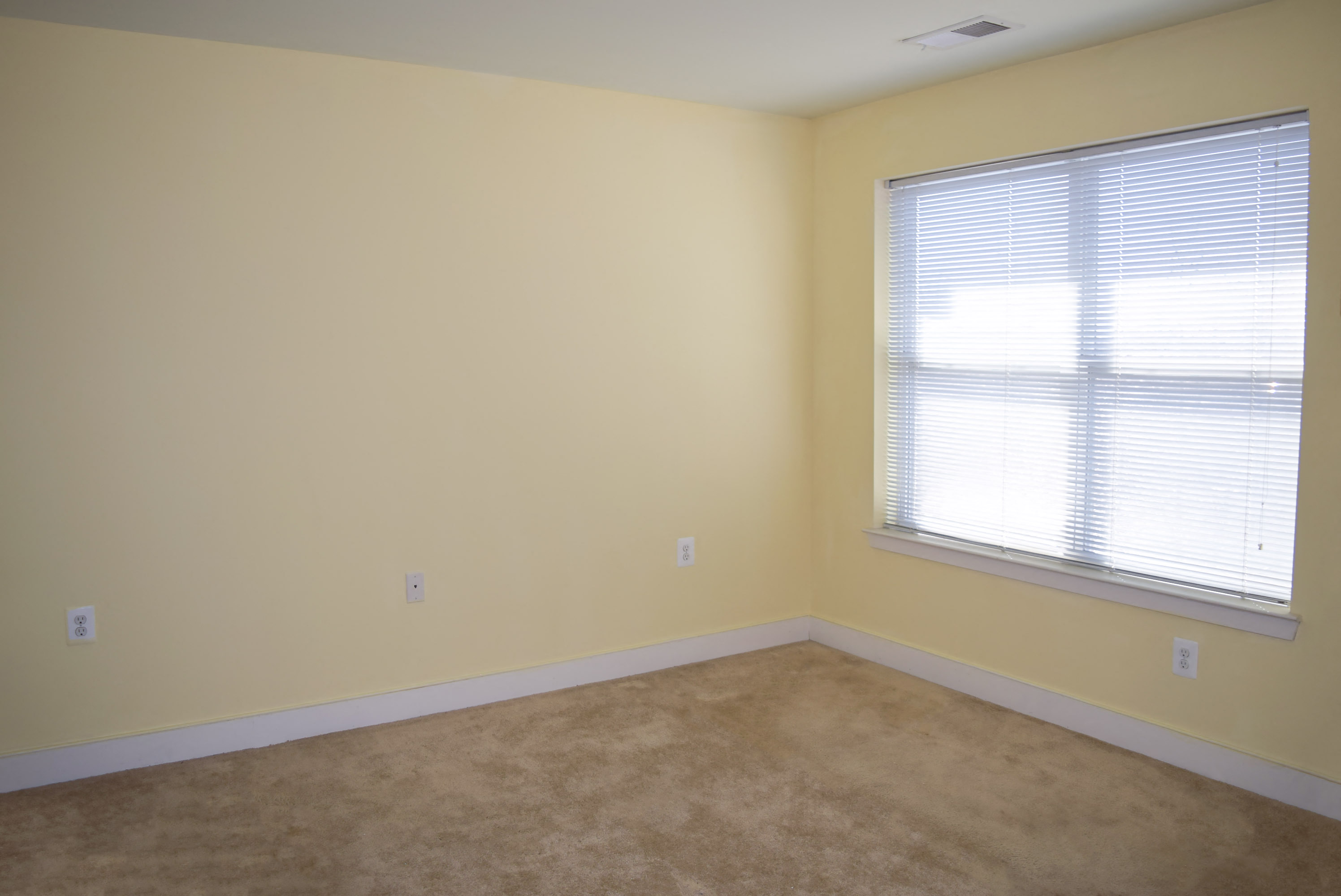 a room with a large window and a carpeted floor