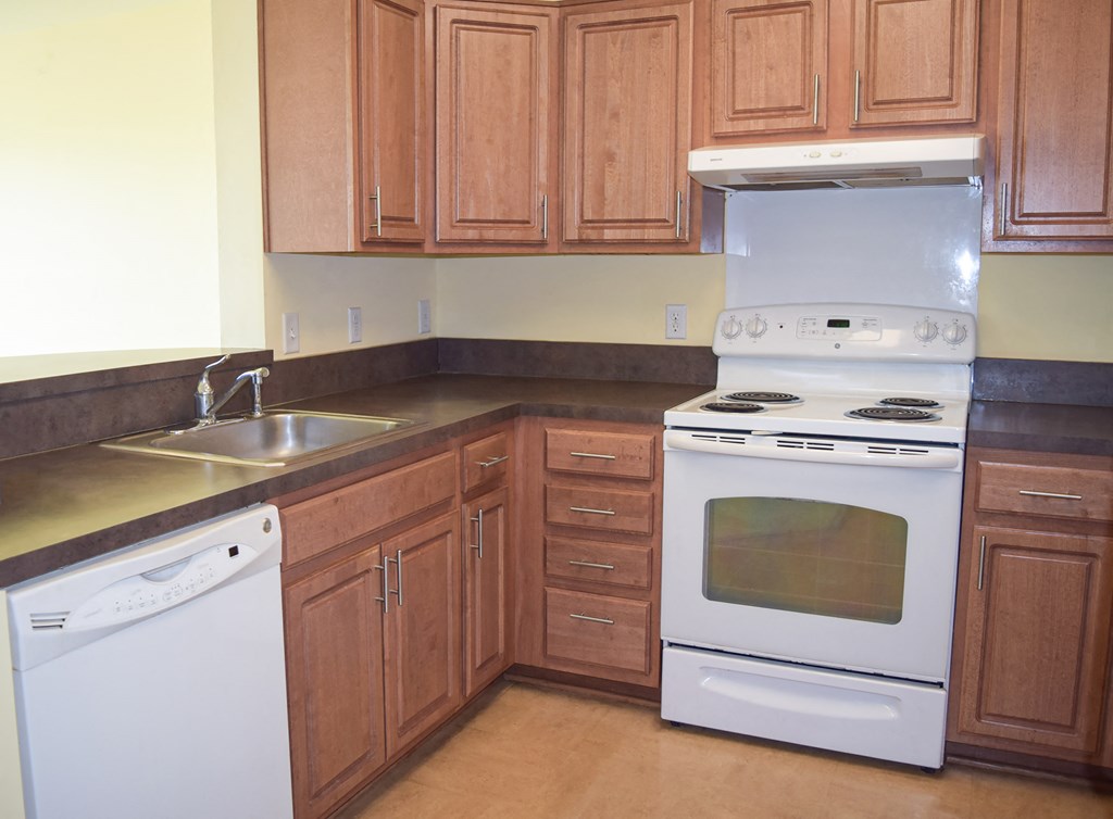 a kitchen with white appliances and wooden cabinets