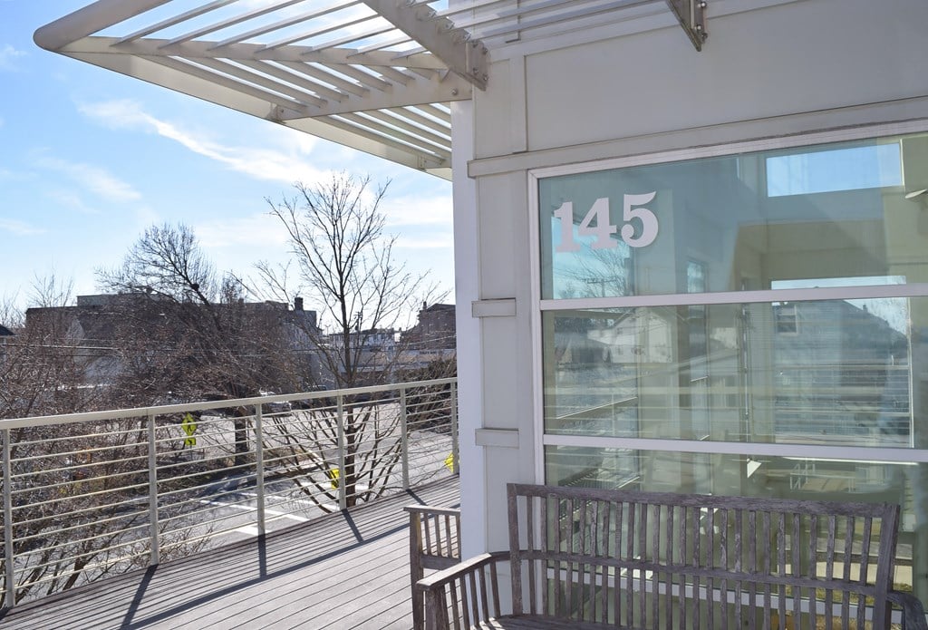 a patio outside a building with a bench and a glass window