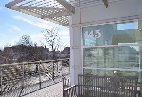 a patio outside a building with a bench and a glass window