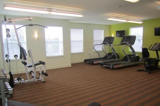 a gym with some exercise equipment and windows