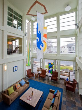 a living room with couches and chairs and a blue rug