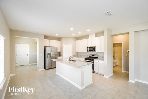 a large kitchen with white cabinets and stainless steel appliances