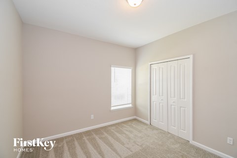 a bedroom with a closet and a door and a window
