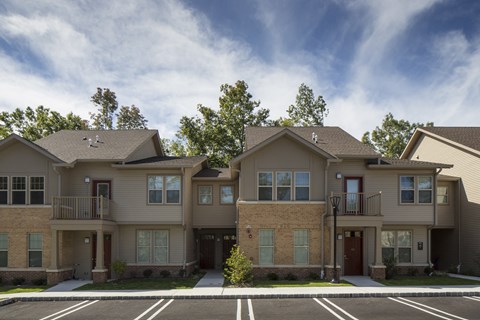 an apartment building with a parking lot in front of it