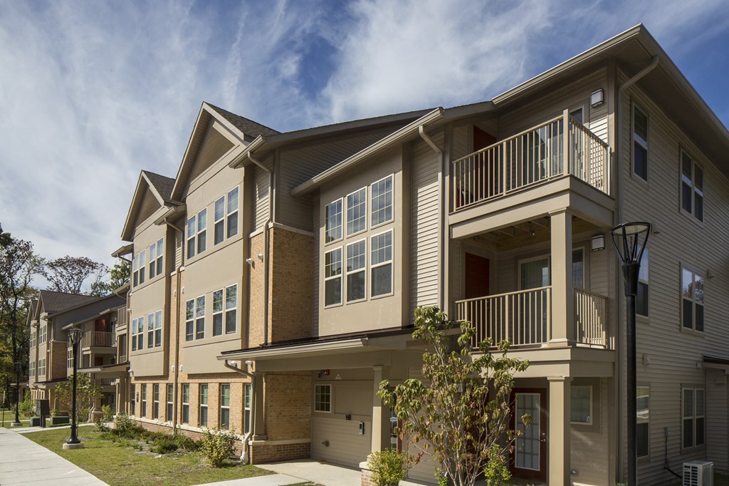 a row of apartment buildings with balconies and a sidewalk