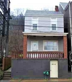 A two-story house with a red brick chimney and a white door.