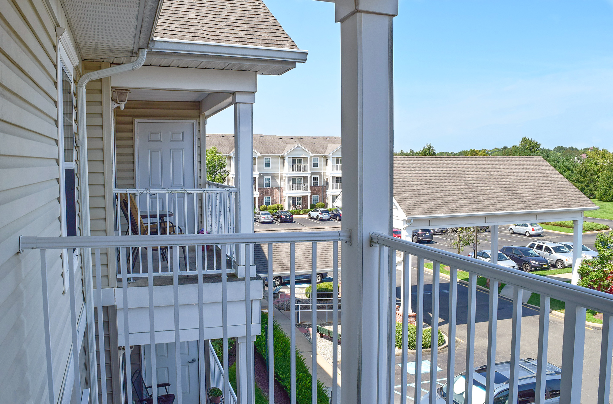 a balcony with a view of a building and a parking lot