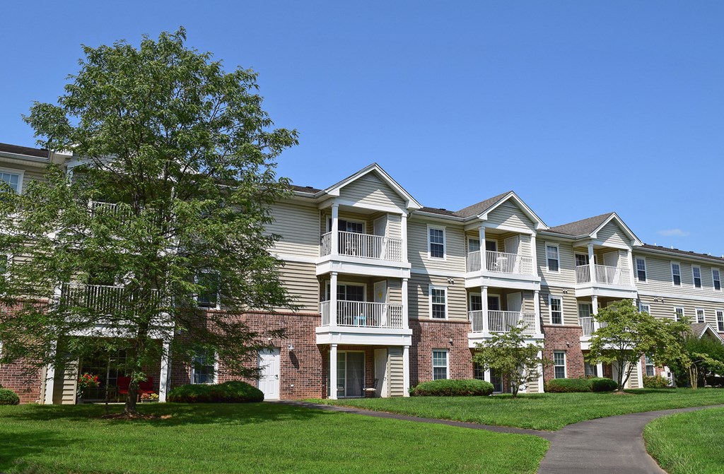 an apartment building with a sidewalk in front of it