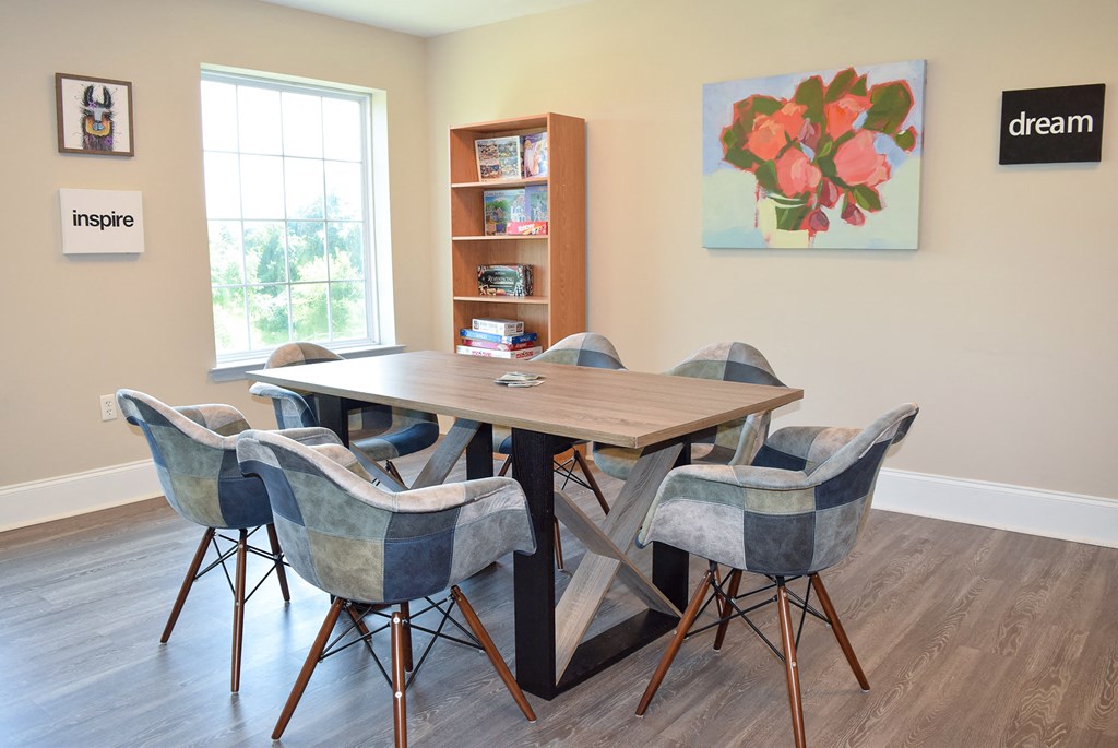a dining area with a table and chairs and a window