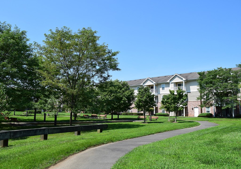 a path through a park with houses in the background