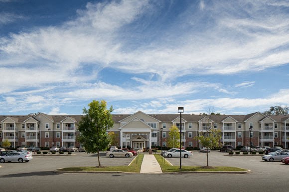 an apartment complex with cars parked in a parking lot