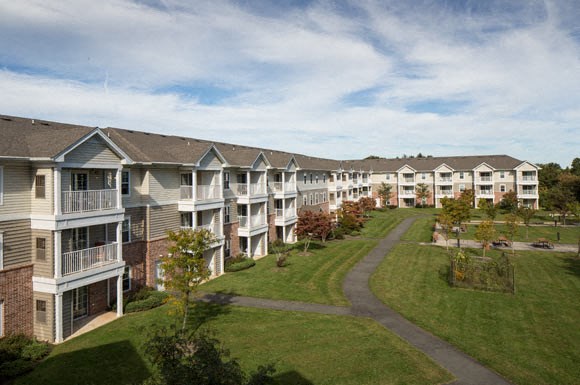 an aerial view of a row of apartment buildings on a green field