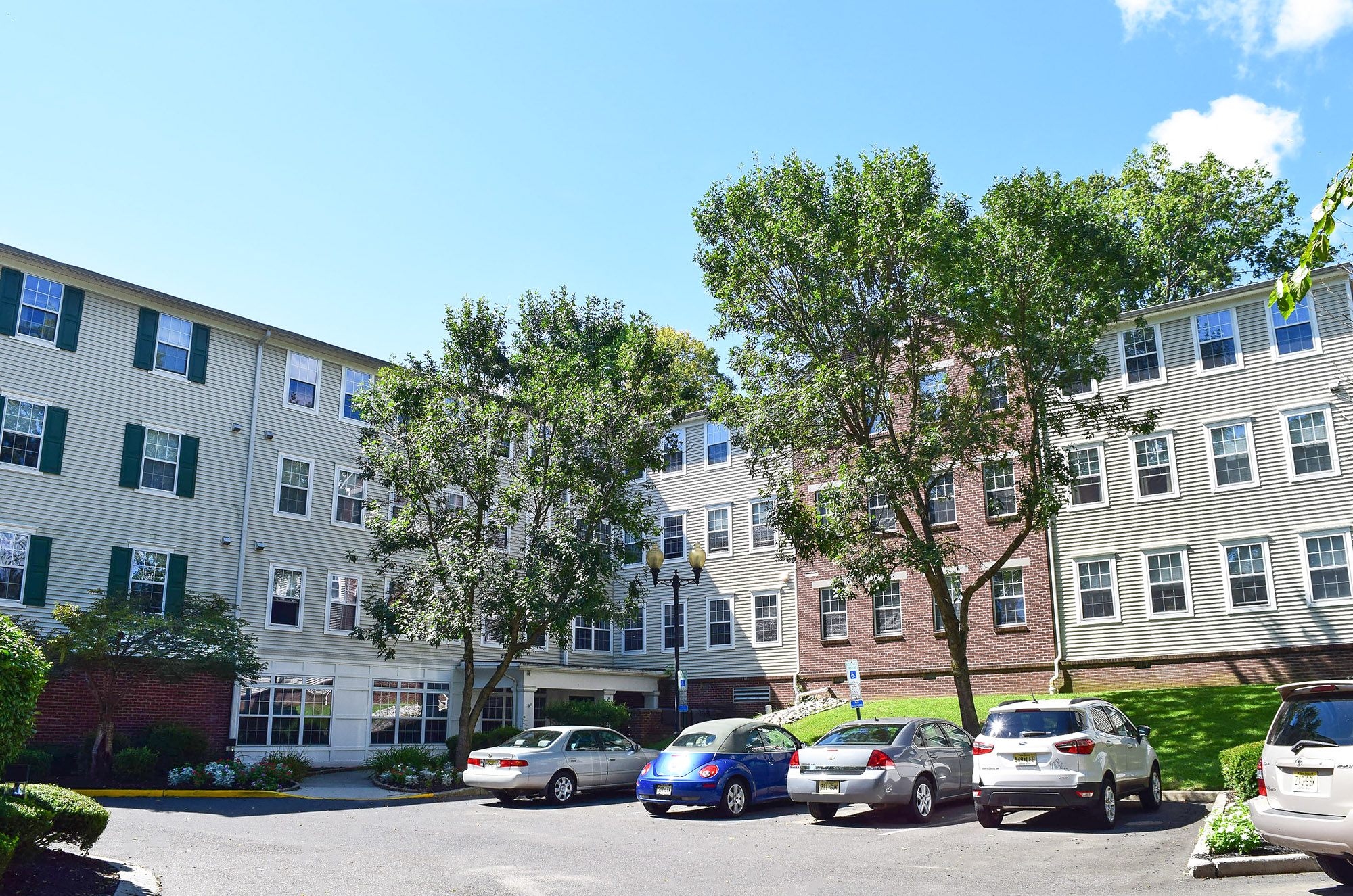 a parking lot in front of an apartment building with cars parked in front