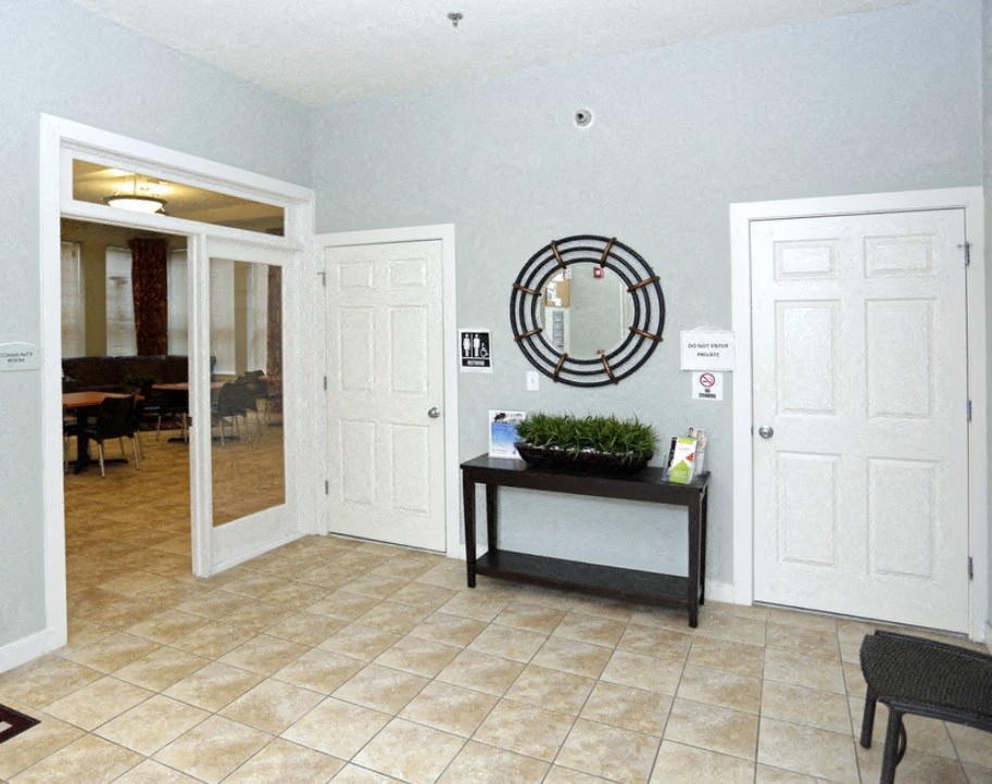 a lobby with two doors and a mirror on the wall