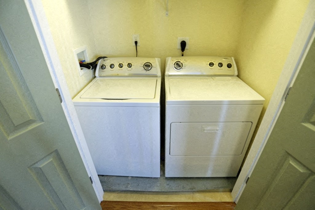 two washers and a dryer in a laundry room