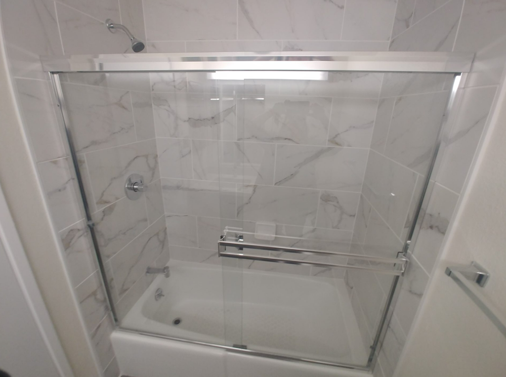 a shower with a glass door in a bathroom