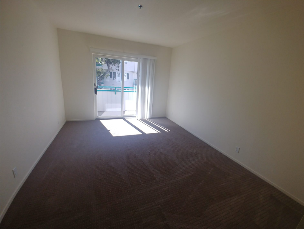 an empty living room with a door to a swimming pool