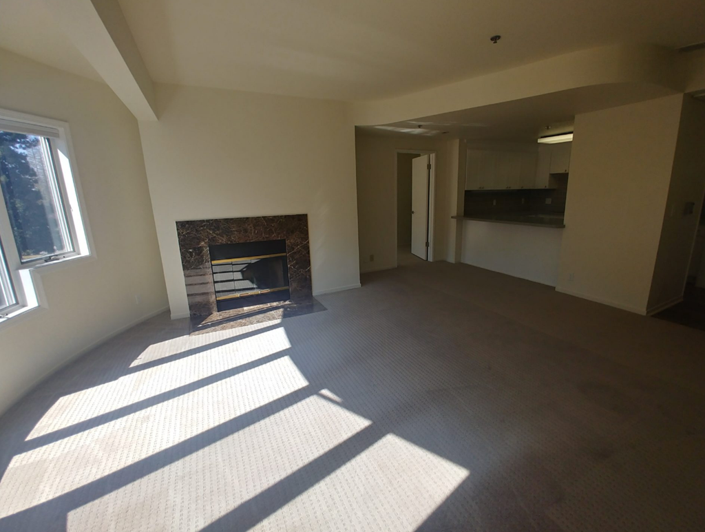 an empty living room with a fireplace