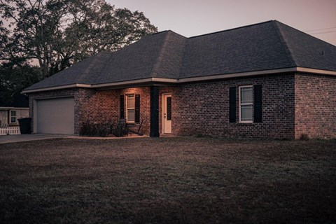 a brick house with a yard in front of it