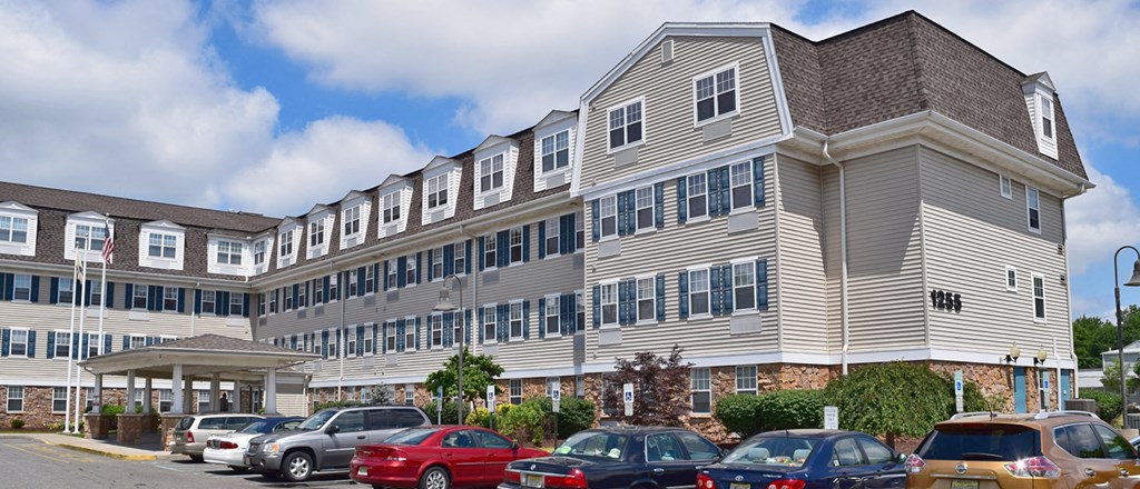 a large apartment building with cars parked in front of it