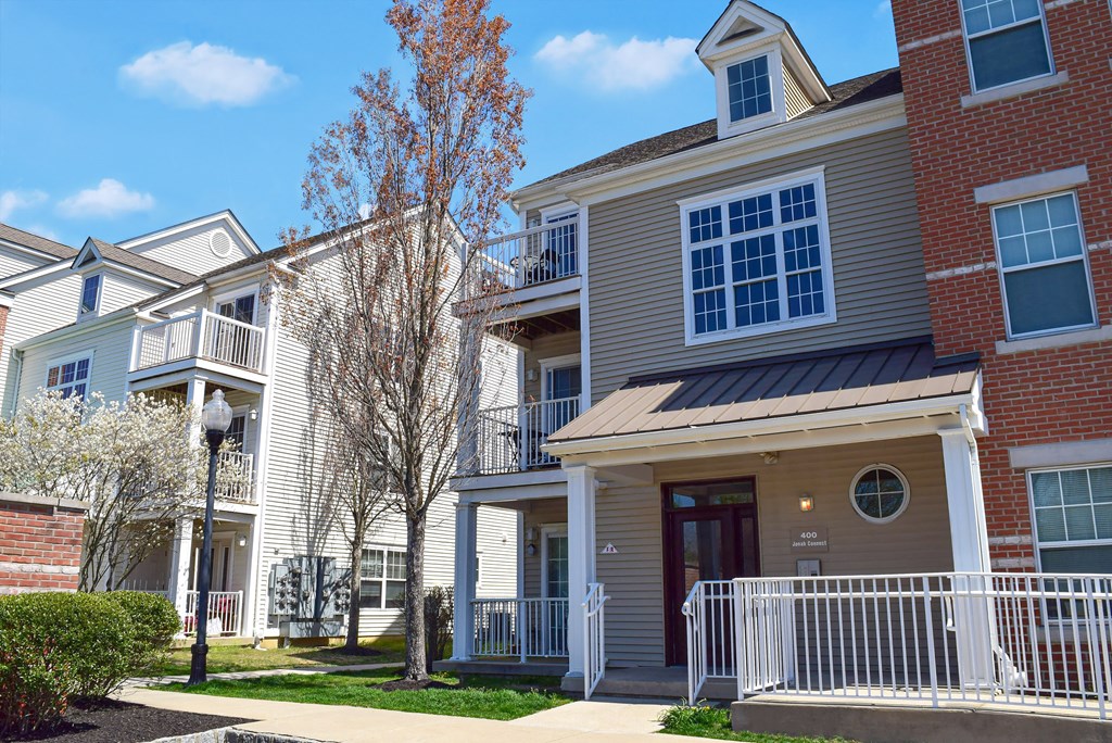 an apartment building with a red brick exterior and a white fence